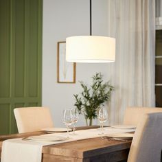 a dining room table is set with wine glasses and place settings for two people to eat