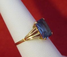 An Original 1960's Swedish 18 Kt Yellow Gold Blue Topaz Ladies Ring - Blue Beauty (Size 6). Visit this shop for a wide variety of Vintage Quality Jewelry, Art, and Collectibles. ~Age (approximate): 1960's ~Material(s): 18 Karat Yellow Gold ~Approx. Size: 6 ~Approx. Weight: 1.4 dwt ~Signature / Brand: Unsigned. ~Condition: Very Good. ~International Shipping: Is Available, please contact us for a quote. ~Inventory #: 6129 Collectible Blue Diamond Cut Ring, Blue Solitaire Ring For Formal Occasions, Vintage Blue Emerald-cut Topaz Ring, Vintage Blue Topaz Ring With Diamond Cut, Vintage Blue Sapphire Ring Emerald Cut, Blue Classic Amethyst Ring For Formal Occasions, Vintage Blue Rings For Formal Occasions, Vintage Blue Ring With Diamond Cut, Vintage Sapphire Topaz Ring For Formal Occasions