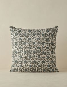 a blue and white pillow sitting on top of a table