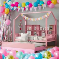 a bedroom with balloons and a bed in the middle is pink, blue, yellow and white