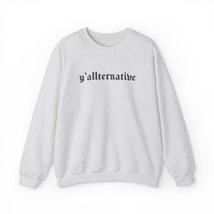 🖤 Blend Southern Charm with Goth Aesthetics in Goth Cloth's 'Yallternative' Long Sleeve Sweatshirt 🖤 Introducing Goth Cloth's 'Yallternative' Long Sleeve Crew Neck Sweatshirt – where the allure of the goth meets the charisma of the South. For those who love to stand out with a unique blend of styles, this sweatshirt is a must-have. Ideal for chilly evenings or cozy days in, it's a statement piece that's as comfortable as it is striking. Key Features: Standout Gothic Font: 'Yallternative' inscribed in a mesmerizing gothic font, perfect for the unconventional. Supreme Comfort: Crafted from 100% Airlume combed and ringspun cotton for a soft, inviting feel. Fit for All: Unisex retail fit, catering to every body type. Ladies, consider a size down for a more fitted look. Durable and Cozy: Ribb Gothic Font, Gothic Chic, Gothic Fonts, Boxy Tee, Southern Charm, Gothic Style, Long Sleeve Sweatshirt, Hoodies Design, Sweatshirt Designs