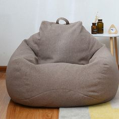 a bean bag chair sitting on top of a wooden floor next to a white table