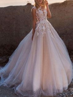 a woman in a wedding dress standing on rocks