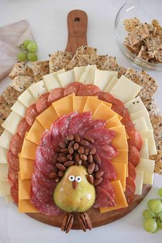 a turkey shaped cheese board with grapes and crackers