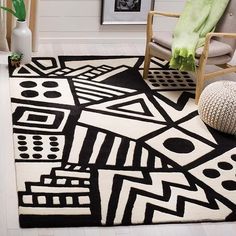 a black and white area rug with geometric shapes on it in a living room setting