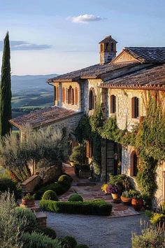 an italian style house surrounded by greenery and stone walls, overlooking the rolling hills