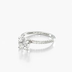 a diamond engagement ring with diamonds on the band and a single stone in the center