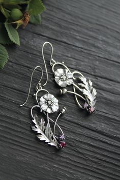 ITEM DESCRIPTION: Size H 65 x W 25 mm (2 1/2 x 2/3 inches) with closure. Weight - 4 g of each other. I made these botanical earrings of sterling silver, rhodolite and amethyst. This is very delicate and detailed work. These summer flowers look really elegant and amazing in silver. You can order these earrings with different gems. If you do not see your favorite version there, please write to me in convo and we will discuss your order. Jewelry will come to you in a gift box - ready for gifting. M Sterling Silver Flower Earrings Fine Jewelry, Leaf-shaped Jewelry With Matching Earrings, Silver Leaf-shaped Handmade Earrings, Leaf-shaped Jewelry With Matching Earrings For Gift, Bohemian Leaf-shaped Jewelry With Ear Wire, Silver Flower Drop Earrings In Fine Jewelry Style, Silver Drop Flower Earrings In Fine Jewelry Style, Nature-inspired Leaf-shaped Jewelry With Matching Earrings, Handmade Silver Botanical Earrings