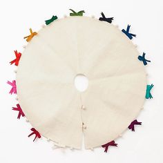 a circular piece of cloth with small colorful birds on the top and bottom, surrounded by white background