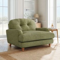 a green chair sitting on top of a rug in a living room