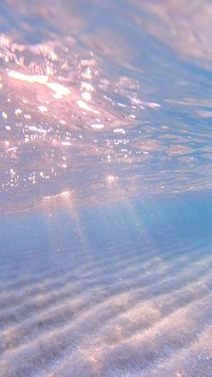 the sun shines brightly through the water as it reflects on the sand under the ocean floor