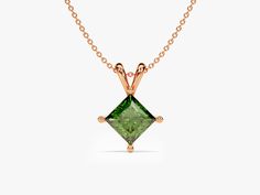 This necklace showcases a single magnificent emerald, celebrated for its rich green color and historical symbolism. Emeralds are often associated with qualities such as rebirth, growth, and fertility. The "double bail" design provides balance and elegance to the pendant, ensuring it hangs gracefully from the chain. The princess cut is characterized by its sharp, square or rectangular shape with pointed corners, which enhances the emerald's natural beauty and brilliance. Fine Jewelry Green Diamond Cut Necklaces, Classic Diamond Cut Necklace For May Birthstone, Formal Diamond Cut Necklace For May Birthstone, Green Diamond-cut 14k Gold Necklace, 14k Gold Green Diamond Cut Necklace, Green Pendant Necklace With Prong Setting, Green Diamond Cut Necklace For Anniversary, Green Pendant Necklaces With Prong Setting, Anniversary Green Diamond Cut Necklace