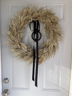 a white door with a black ribbon and a wreath hanging on it's side