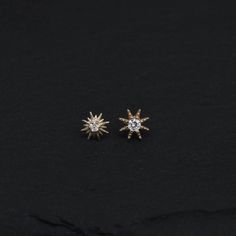 pair of sun and star earrings on black background