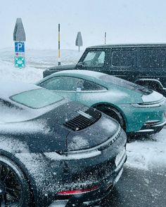 two cars are covered in snow on the road