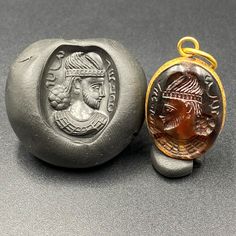 an ancient roman coin next to a wax seal