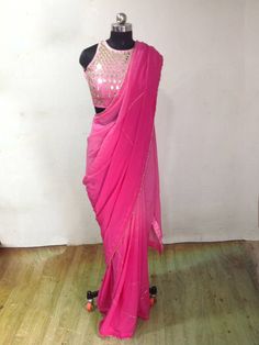 Graded pink ( light to dark) georgette embroidery saree with beautiful zardosi embroidery lines. Blouse is available as a seperate listing. The saree can be made in other colors as well Blouse: https://www.etsy.com/listing/957833251/custom-fit-graded-pink-mirror-work Festive Pink Pre-draped Saree With Mirror Work, Festive Pink Pre-draped Saree With Dori Work, Pink Chinon Sharara With Cutdana Detail, Pink Chinon Pre-draped Saree For Navratri, Designer Pink Pre-draped Saree With Zari Work, Pink Party Wear Choli With Cutdana, Pink Saree With Gota Work, Pink Dupatta With Cutdana For Party, Pink Party Wear Pre-draped Saree With Mirror Work