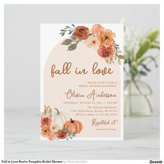 the fall in love wedding card is displayed on a table with flowers and greenery