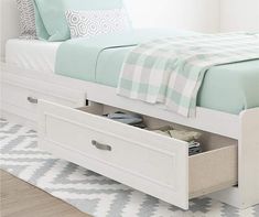 a white bed with two drawers underneath it