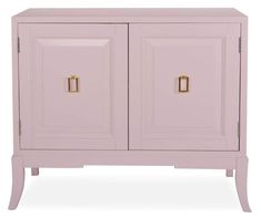 a pink cabinet with two doors and gold handles