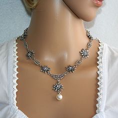 Fascinating and noble costume necklace antique silver with 7 edelweiss and a pearl pendant on a stainless steel chain. Each edelweiss is equipped with 8 small and one large crystal-colored rhinestone in the middle. If more Edelweiss are desired for the Edelweiss chain, these can be ordered with the *Edelweiss quantity* option. This beautiful necklace is comfortable to wear and lies beautifully on the neck. It enhances your dirndl or traditional dress and completes your outfit.  The size of the e Edelweiss Necklace, Edelweiss Flower, Costume Necklace, Costume Necklaces, Necklace Antique, Necklace Women, Pearl Pendant Necklace, Traditional Dress, Stunning Necklace