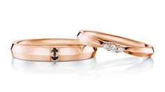 two rose gold wedding rings with black and white diamonds on each one, set against a white background