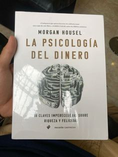 a person holding up a book in front of their face with the title la pisicologia del dinero written on it