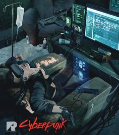 a woman laying on top of a couch next to a computer monitor and keyboard in a room