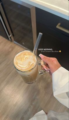 a woman holding a cup of coffee in her hand with the words good morning on it