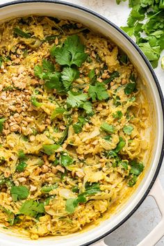 a large pot filled with food and garnished with cilantro, parsley