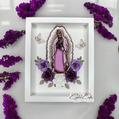 an image of the virgin mary with purple flowers in front of it on a white background