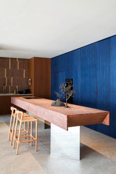 a large wooden table sitting in the middle of a room next to two stools