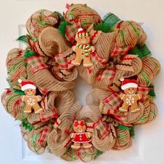 a burlock wreath decorated with christmas decorations and gingerbreads on the front door