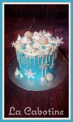 a blue and white frosted cake with snowflakes on it