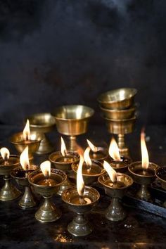 many small candles are lit on a table