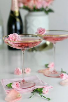 two glasses filled with pink liquid on top of a table