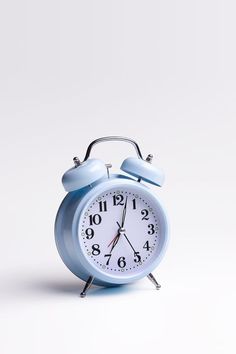 a blue alarm clock sitting on top of a white table