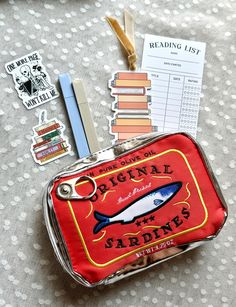 a small tin with some stickers on top of it next to scissors and other items