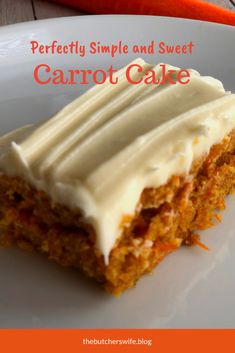 a carrot cake with white frosting sitting on a plate next to an orange carrot