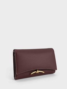 In a gorgeous chocolate brown, this neutral-toned Huxley wallet is made for those with a penchant for understated designs. From the sleek curved flap to the knotted gold-toned metallic accent, this accessory has a classic-with-a-twist design that will inject fun into your everyday outfit. Functional and sleek, this wallet has more than enough space to hold your essentials, while staying slim enough to slip into your bag or back pocket with ease. More Than Enough, Charles Keith, Everyday Outfit, Metallic Accents, Neutral Tones, Chocolate Brown, You Bag, Card Wallet, Dark Chocolate