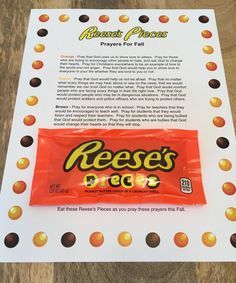 a piece of candy bar sitting on top of a wooden table next to a sign that says reese's donuts