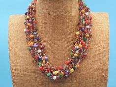 This bright multi strand necklace if full of colorful Czech beads and natural stones. It is the beautiful workmanship by one of our group of Mayan women in the village of Santiago Atitlan, Guatemala. The necklaces' 12 strands can be worn layered or twisted for a more dramatic effect. Each necklace is individually handmade; therefore there may be a slight variance in the placement and color of the natural stones and beads 24 " tip to tip Toggle closure with 3 adjustment loops Multicolored Czech b Colorful Bohemian Faceted Beads, Artisan Multicolor Multi-strand Beads, Artisan Multicolor Multi-strand Beaded Necklaces, Artisan Multicolor Necklaces With Spacer Beads, Multicolor Necklaces With Spacer And Round Beads, Artisan Multi-strand Faceted Beads, Multicolor Multi-strand Beads For Jewelry Making, Artisan Multicolor Oval Beaded Necklaces, Handmade Multicolor Double Strand Beads