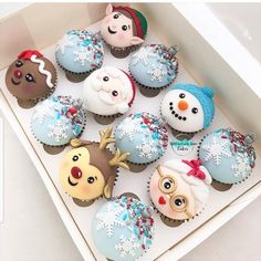 a box filled with cupcakes covered in frosting and decorated like snowmen