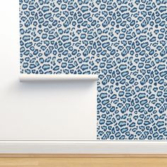 a blue and white leopard print wallpaper in an empty room with wood flooring