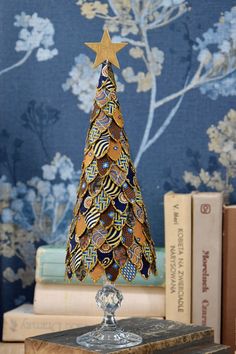 Gold Christmas tree, Christmas table decoration This original and unique decoration was made from scraps of silk. It measures approx.  11 inches  (28 cm). All the small pieces of fabric were each cut by hand and glued to a styrofoam cone. The edges of each piece are dipped in glitter.  The whole tree sits on a beautiful glass stand. There is a small, light, wooden star on the top. Have a look at other offers of Christmas tree:  https://www.etsy.com/pl/shop/moffka?ref=shop-header-name&listing_id=1325258478&section_id=44223404 Please check my other listings (pinecone) and combine  a nice set of Christmas decor: https://www.etsy.com/pl/shop/moffka?ref=seller-platform-mcnav&section_id=39399592 You may also have a look at my other Christmas decorations made from yellowed old book pages: https:/ Styrofoam Christmas Tree, Jewelry Tree Craft, Lace Christmas Tree, Gold Christmas Decor, Christmas Table Decoration, Fabric Tree, Fabric Christmas Trees, Cone Christmas Trees, Unique Christmas Ornaments