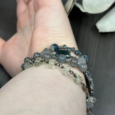 This incredible wrap bracelet has been a work in progress for a while. The combination of the pewter focal with the gorgeous 6mm flashy labradorite rounds absolutely enchanted me. From there, I added so many of my favorite things. In this bracelet, you’ll find apatite rectangles, the most insane faceted 8mm kyanite, 8mm starcut pale jade, flashy tourmilinated rainbow moonstone, smoky quartz, and the most incredible faceted prasiolite nuggets. Also featured are the prettiest faceted glass rondelles. Let’s circle back to the focal. The shape was so interesting and mysterious to me. I wrapped on faceted labradorite and iolite to bring out some of the lines. This wrap bracelet is sterling silver, with the exception of the USA made pewter focal. The knotted portion of the bracelet was done in h Elegant Multi-strand Gemstone Beaded Bracelets, Elegant Multi-strand Beaded Wrap Bracelet, Silver Beaded Multi-strand Wrap Bracelet, Bohemian Silver Multi-stone Bracelets, Bohemian Multi-stone Sterling Silver Bracelets, Bar Bracelets, A Work In Progress, Faceted Glass, My Favorite Things