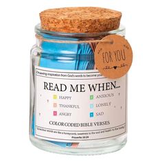 a jar filled with blue and green colored paper next to a cork tag that says read me when