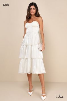 a woman is wearing a white dress with tiered ruffles on the bottom