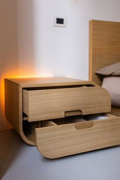 a wooden bed with two drawers on the bottom and one drawer open in front of it