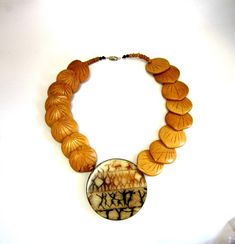 "This fabulous vintage necklace has a very ethnic feel to it, and I believe it was made in Africa, circa 1970's. It features very interesting hand carved nuts that lead down to the brass medallion centerpiece. The natural colors of the centerpiece highlight the abstract painting of dancers in rusty browns and blacks. A barrel clasp and small wooden beads finish off this unique beauty. In excellent condition, with the only wear noted on the back of the medallion. The barrel clasp is in perfect wo Unique Medallion Necklaces For Festivals, Carved Medallion Necklace For Jewelry Making, Carved Medallion Necklaces For Jewelry Making, Adjustable Carved Gold Necklaces, Adjustable Carved Gold Necklace, Unique Brown Necklaces For Festivals, Traditional Carved Medallion Necklaces, Adjustable Gold Carved Necklace, Traditional Carved Medallion Necklace